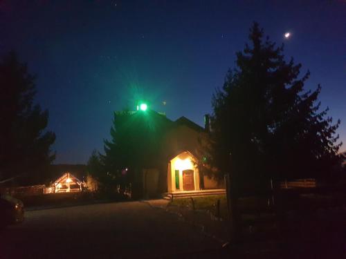 a house with a green light on top of it at night at Pensiunea Petra Verde in Porumbacu de Sus