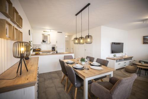 ノルトホルンにあるFerienwohnung Casa Mila - Nordhornのテーブルと椅子のあるダイニングルームとキッチン