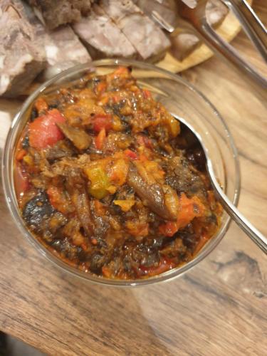 a bowl of food on a table with a spoon at Pensiunea Petra Verde in Porumbacu de Sus