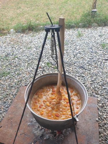 a pot of food with a wooden stick in it at Pensiunea Petra Verde in Porumbacu de Sus