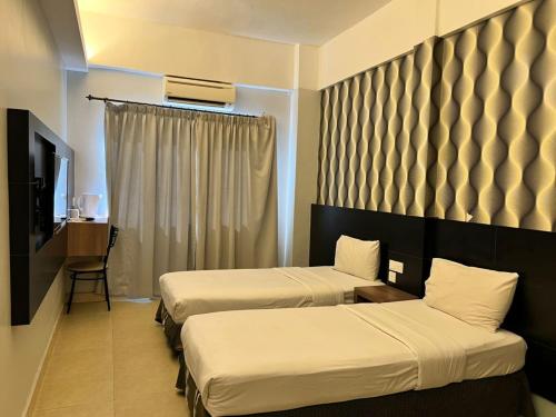 a hotel room with two beds and a television at Dancenter Near Shell Jalan Iskandar Shah, Orchard in Kampong Tebing Rabak
