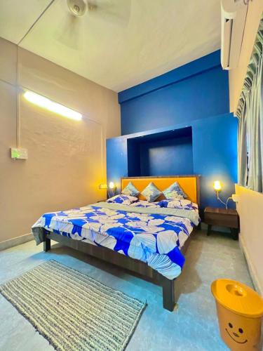 a blue bedroom with a bed with a blue wall at Nature View Villa - The Dream Stays ll Big Infinity Pool ll Wifi ll Ac ll Garden in Lonavala