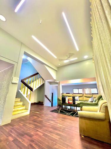 a living room with a couch and a staircase at Nature View Villa - The Dream Stays ll Big Infinity Pool ll Wifi ll Ac ll Garden in Lonavala