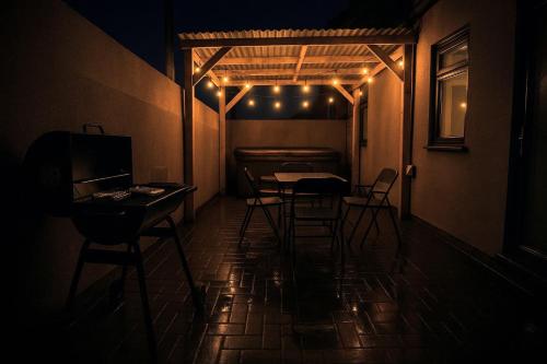 a dark room with a table and chairs and lights at Numero Uno Ensuite 3BR Flat Hot Tub Wifi Parking Contractor and Group Friendly in Birtley