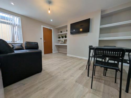 a living room with a couch and a table and chairs at Numero Uno Ensuite 3BR Flat Hot Tub Wifi Parking Contractor and Group Friendly in Birtley