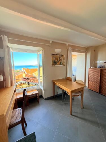 une salle à manger avec une table et une fenêtre dans l'établissement Charmant Studio Perché sur Mer - Vieux Menton, à Menton