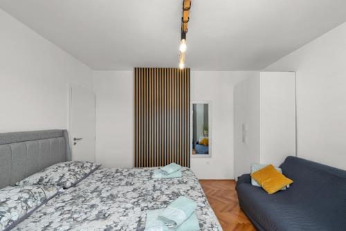 a bedroom with a bed and a couch at Kala Sea View Apartments 150m from beach and 250 m from old town in Poreč