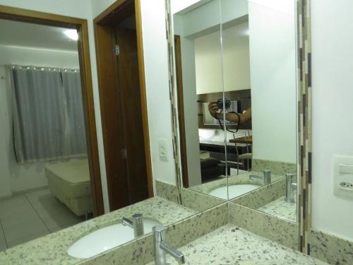 a bathroom with two sinks and a large mirror at Apartamentos Riviera Park in Caldas Novas