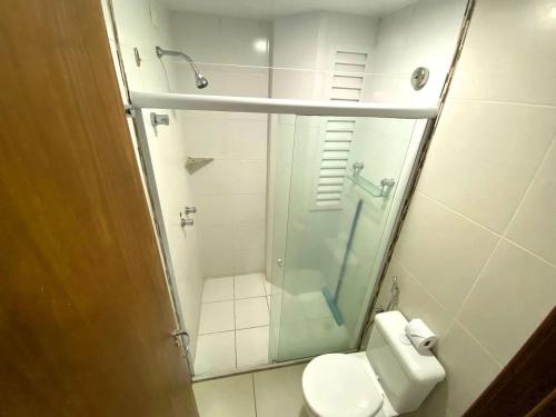 a bathroom with a toilet and a glass shower at Apartamentos Riviera Park in Caldas Novas