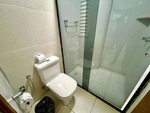 a bathroom with a toilet and a glass shower at Apartamentos Riviera Park in Caldas Novas
