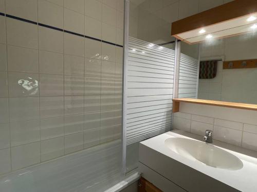 une salle de bain avec un lavabo, une baignoire et un miroir dans l'établissement Studio confortable, proche pistes, animaux admis - FR-1-356-525, à Valmorel