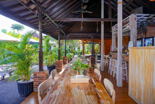 una larga mesa de madera y sillas en un restaurante en Uluwatu Jungle Villa, en Uluwatu