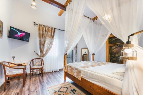 a bedroom with a bed and a table and chairs at Pensiunea Petra Verde in Porumbacu de Sus
