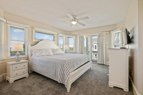 een slaapkamer met een bed, een plafondventilator en ramen bij SNH345 Take It to the Limit in Nags Head