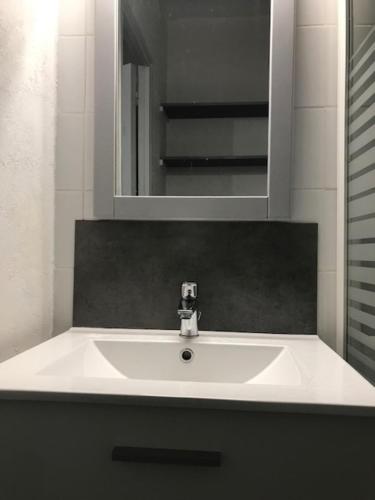 a white sink in a bathroom with a mirror at La SOURCE FROIDE in Eaux-Bonnes