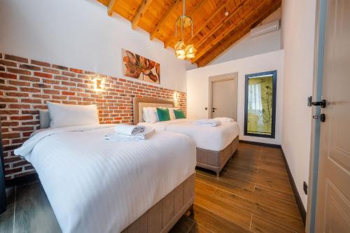two beds in a room with a brick wall at Grand Paradise Resort Sapanca in Sapanca