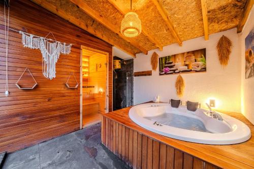 a large bathroom with a tub in a wooden wall at Grand Paradise Resort Sapanca in Sapanca