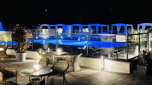 un restaurant avec des tables, des chaises et des lumières bleues dans l'établissement Domaine du parc, à Grandvillers