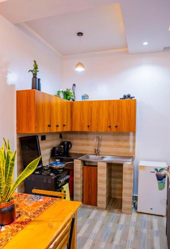 a kitchen with wooden cabinets and a sink and a stove at Valley View KK 191 in Kigali
