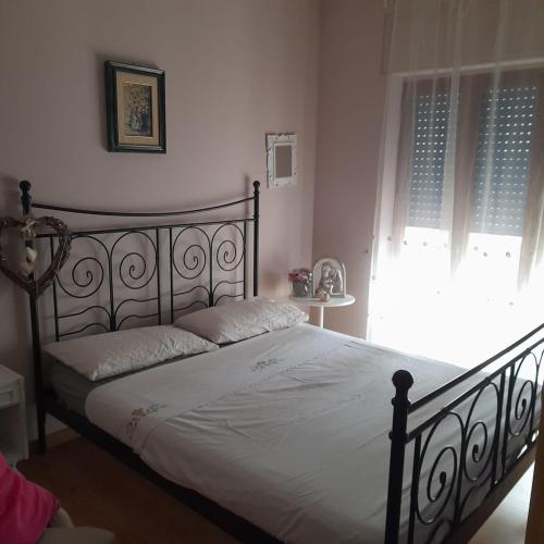 a bedroom with a bed with white sheets and a window at La Casa di Raffa in Agropoli