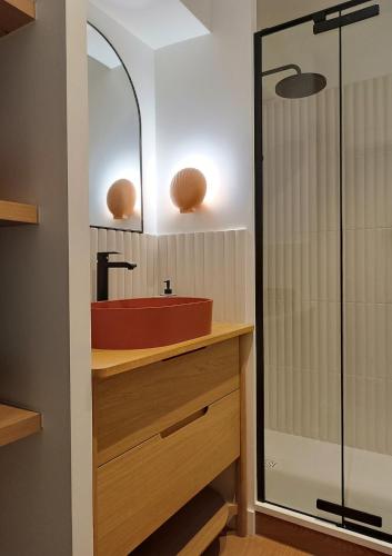 La salle de bains est pourvue d'un lavabo rouge et d'une douche. dans l'établissement Superbe appartement haut de gamme 4 personnes en Front de mer, à Plérin