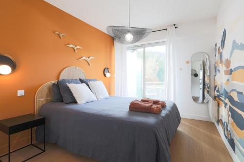 a bedroom with a bed with an orange wall at Superbe appartement haut de gamme 4 personnes en Front de mer in Plérin