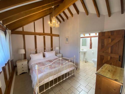 a bedroom with a bed and a chandelier at Oak Apple in Plaitford
