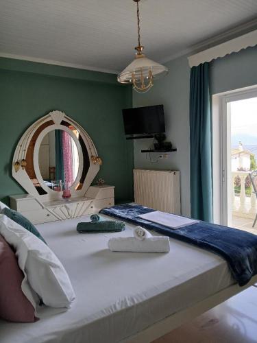 a bedroom with a large bed with a mirror at Helen's Seaside Apartment in Nafpaktos