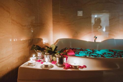 a bath tub with candles and flowers on a table at The Verda De Miranda Resort Morjim North Goa in Morjim