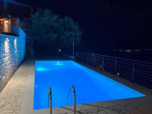 a swimming pool with blue lighting at night at Villa Galini in Astros