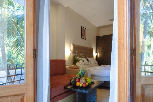 a room with a bed and a table with fruit on it at The Verda De Miranda Resort Morjim North Goa in Morjim