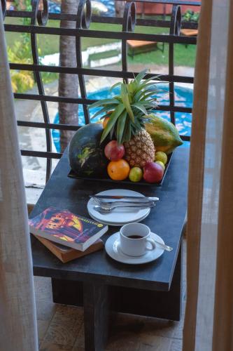 a table with a tray of fruit and a cup of coffee at The Verda De Miranda Resort Morjim North Goa in Morjim