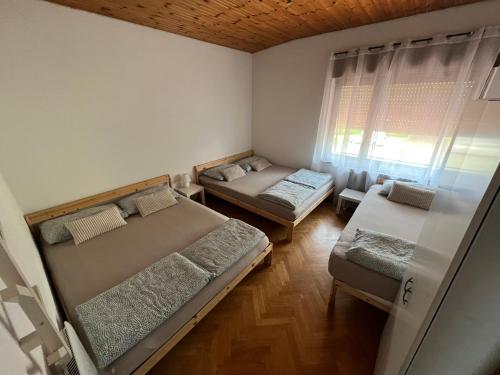 a small room with two beds and a chair at Apartma Magnolija in Nova Gorica