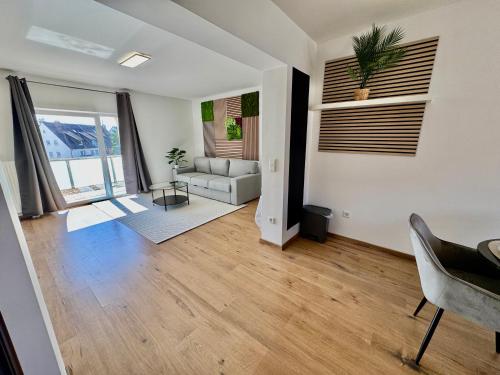 a living room with a couch and a table at FeWo-Palmtrees 4 - Große moderne 2 Zimmerwohnung mit Süd-West Balkon in Gladbeck-Mitte Nähe Movie Park und Arena AufSchalke in Gladbeck
