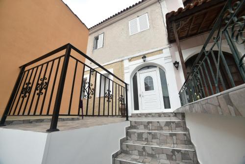 a staircase leading to a house with a white door at Nicol apartment in Skoutaros