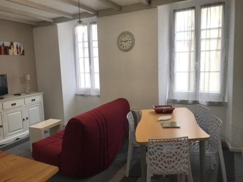 un salon avec une table et un canapé rouge dans l'établissement La SOURCE FROIDE, à Eaux-Bonnes