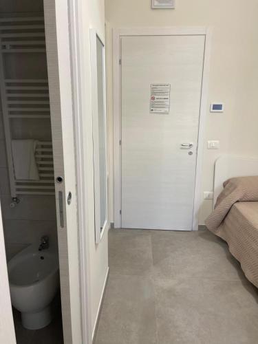 a bathroom with a toilet and a door with a sink at Palazzo dei Baroni in San Bartolomeo in Galdo