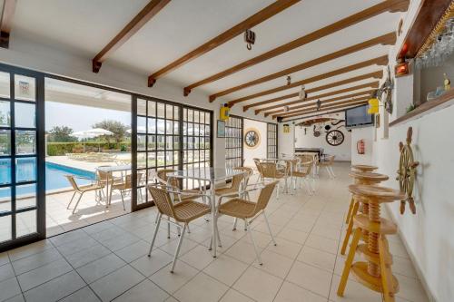 a dining room with a table and chairs and a pool at Muthu Balaia Sol in Albufeira