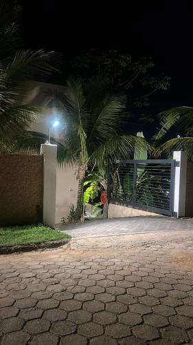 een oprit met een poort en palmbomen 's nachts bij Maluhia Ilhabela 1 in Ilhabela