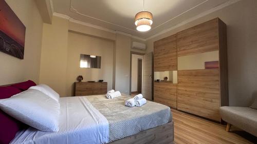 a bedroom with a large bed with two towels on it at Albachiara Apartment vicino al mare di Capaci in Capaci