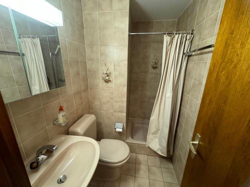a bathroom with a sink and a toilet and a shower at Mandarin B10 in Crans-Montana