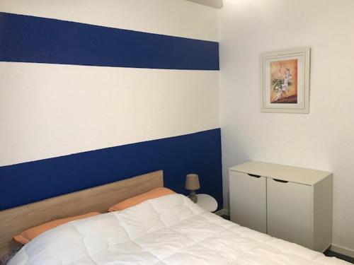 a bedroom with a blue and white wall and a bed at La SOURCE FROIDE in Eaux-Bonnes