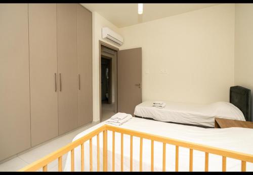 two beds in a room with a balcony at Protaras The Icon 001 at Mythical Seas in Paralimni