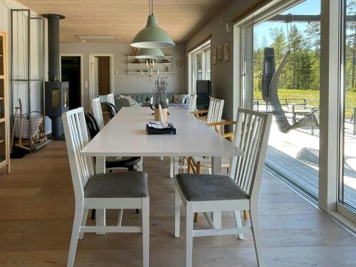 a dining room with a white table and chairs at Lake Cottage With Sunsets Over Försjön in Eksjö
