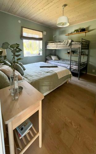 a bedroom with two bunk beds and a table at Lake Cottage With Sunsets Over Försjön in Eksjö