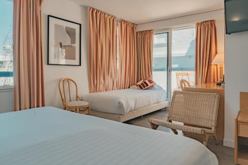 a hotel room with a bed and a desk at Hôtel Édenia - Spa Estime&Sens in Carnac