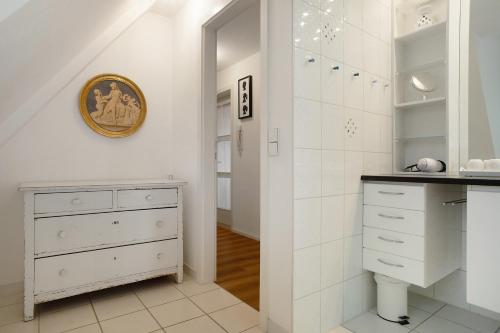 a white bathroom with a sink and a cabinet at Gästezimmer Cleo in Uhldingen-Mühlhofen