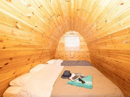 Cette petite chambre comprend un lit dans une cabane en bois. dans l'établissement Cabane 3 étoiles - eeid0d, à Bagneaux-sur-Loing