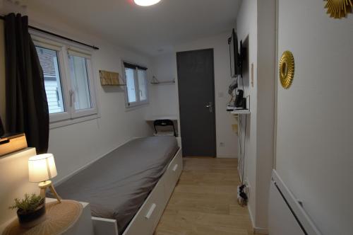 une petite pièce avec un lit et une fenêtre dans l'établissement Petit studio centre ville boucle, à Besançon