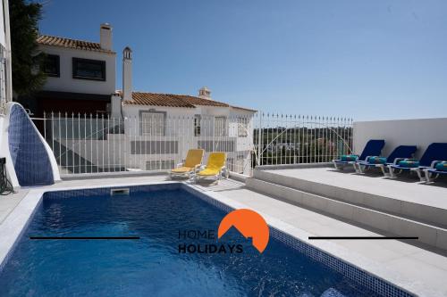 #248 Villa Loureira 54 by Home Holidays في Páteo: مسبح وكراسي ومنزل